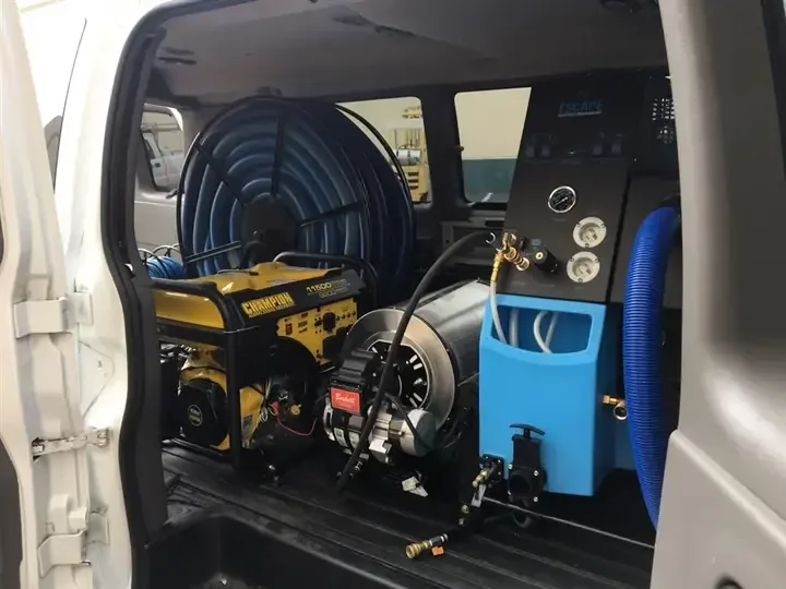 A truck-mounted extraction unit and hose reel ready for a water removal job
