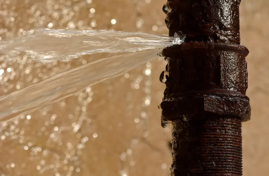 A burst supply pipe spraying water inside a home