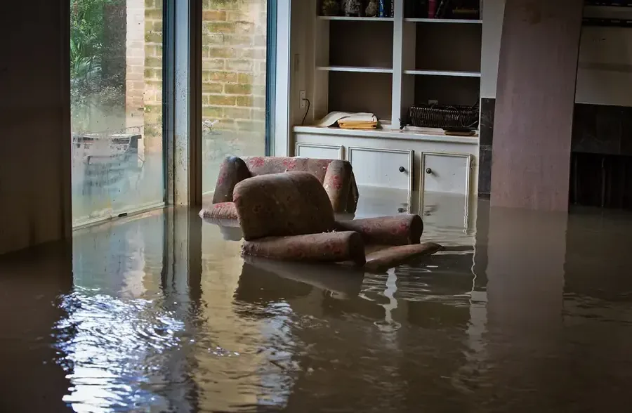 Muddy floodwater standing across the floor inside a home